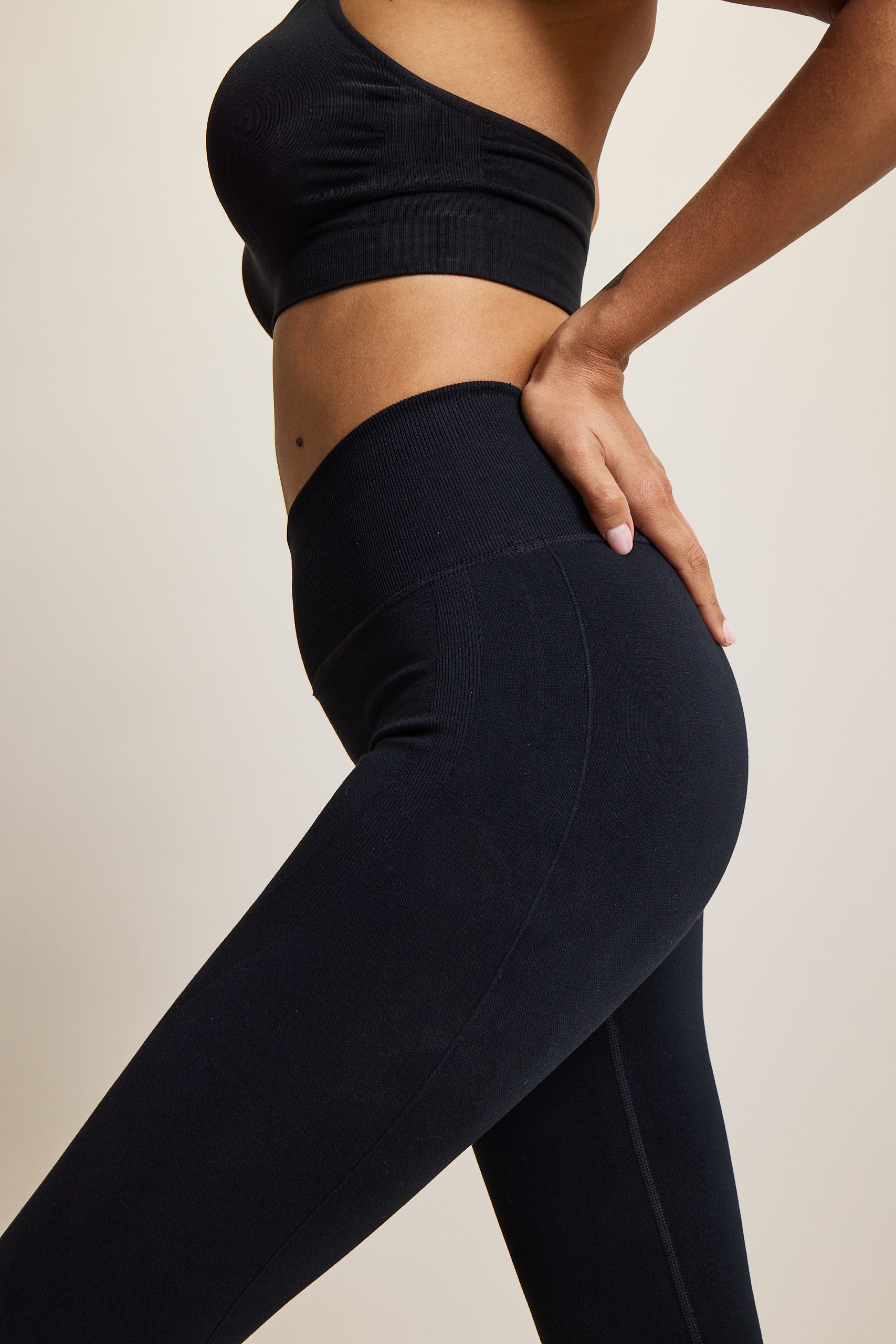 High-waisted black seamless sculpting leggings for women in eco-friendly fabric, perfect for athleisure, activewear, and yoga. Moisture-wicking and squat-proof design ideal for performance, workout, and fitness activities. Fashionable, figure-hugging leggings offering tummy control and breathable comfort, crafted from sustainable materials for versatile all-day wear.