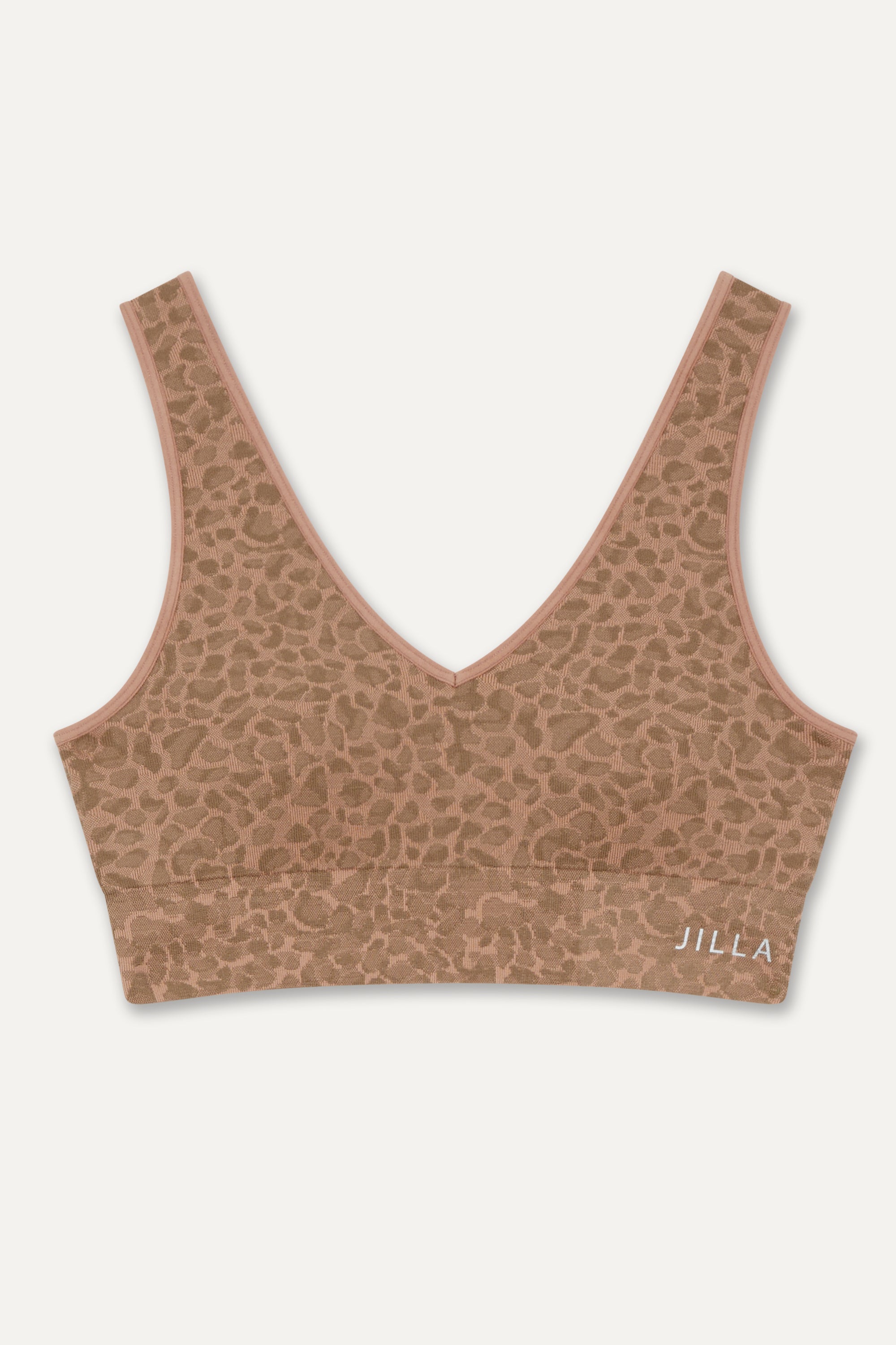 Get summer-ready with our brown Sahara Recycled Sports Bra, seamlessly knitted in our new animal jacquard. Designed with a flattering V-neck shape, comfortable straps, and a wide underband, this bra offers light to medium support for low-impact studio exercise, cycling, and gym sessions. The double-layered fabric ensures support and flexibility, while removable pads allow you to customize your fit. Pair it with the matching shorts for a studio-to-street look from sustainable activewear brand Jilla Active
