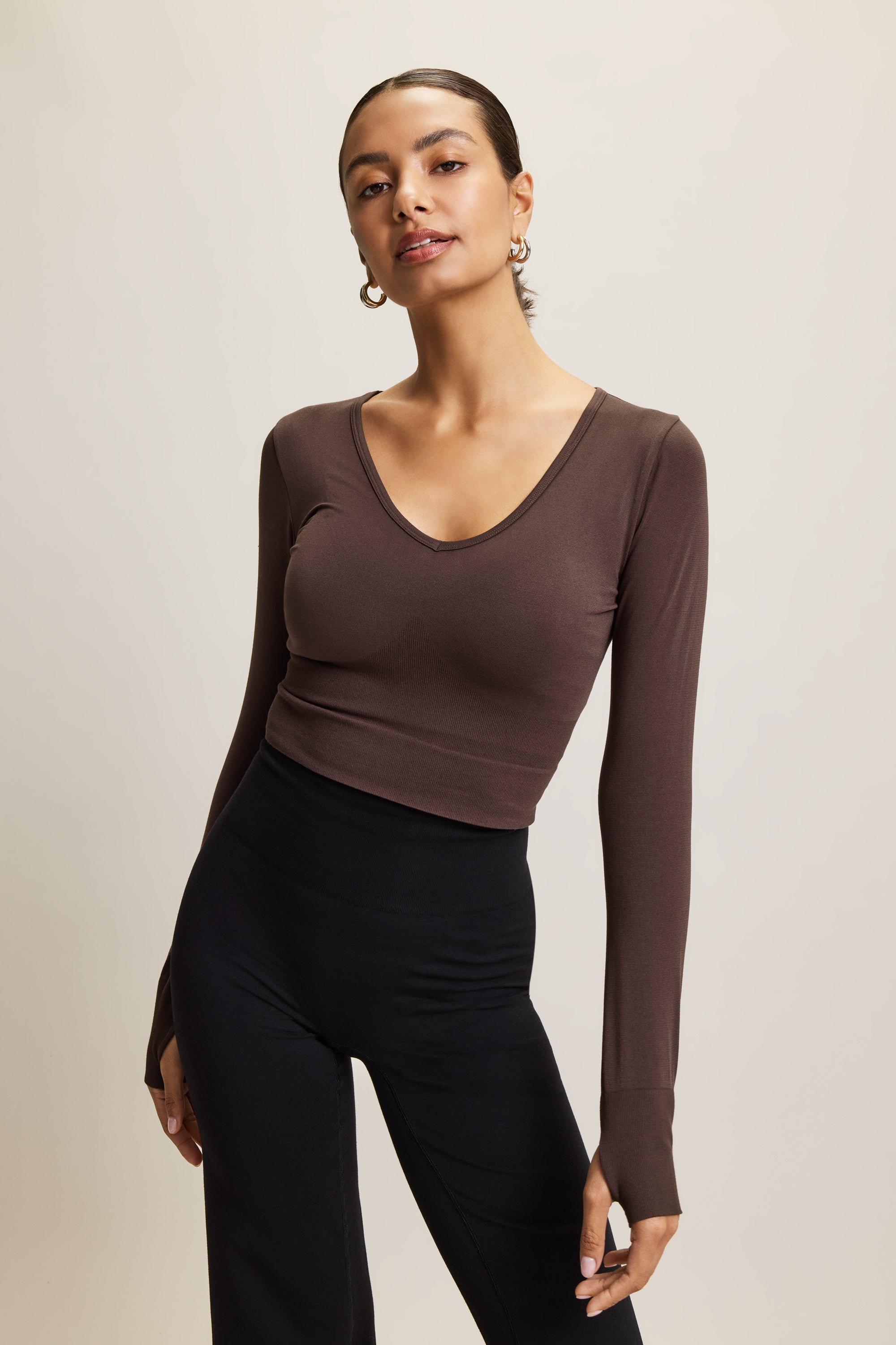 Jilla Active brown stylish cropped long-sleeve athleisure top made from eco-friendly bamboo fabric, featuring a flattering V-neckline, thumbholes for added comfort, and contouring panels for a sculpted fit. Perfect for activewear, this moisture-wicking and breathable top is ideal for workouts, yoga, and casual everyday outfits.