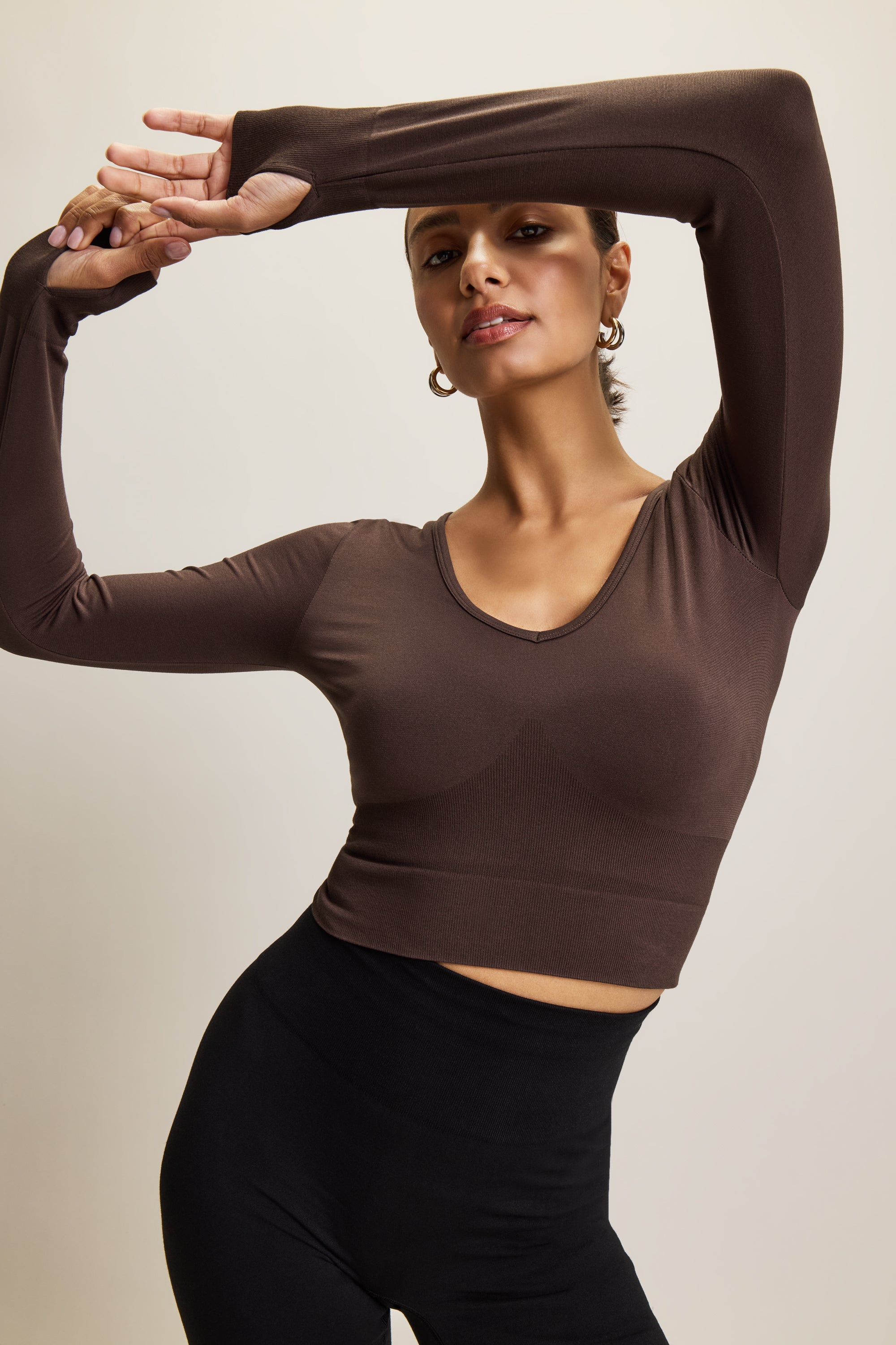 Jilla Active brown stylish cropped long-sleeve athleisure top made from eco-friendly bamboo fabric, featuring a flattering V-neckline, thumbholes for added comfort, and contouring panels for a sculpted fit. Perfect for activewear, this moisture-wicking and breathable top is ideal for workouts, yoga, and casual everyday outfits.