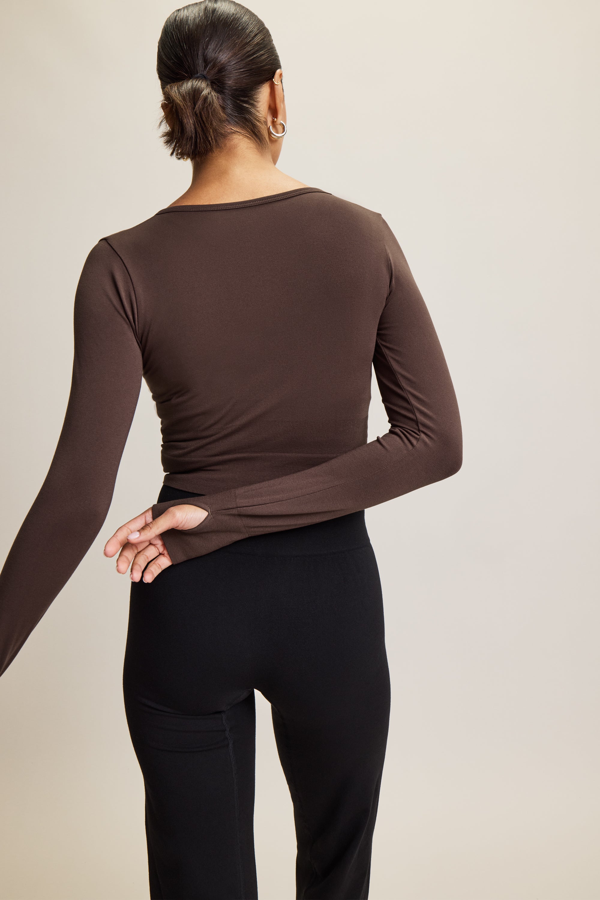 Jilla Active brown stylish cropped long-sleeve athleisure top made from eco-friendly bamboo fabric, featuring a flattering V-neckline, thumbholes for added comfort, and contouring panels for a sculpted fit. Perfect for activewear, this moisture-wicking and breathable top is ideal for workouts, yoga, and casual everyday outfits.