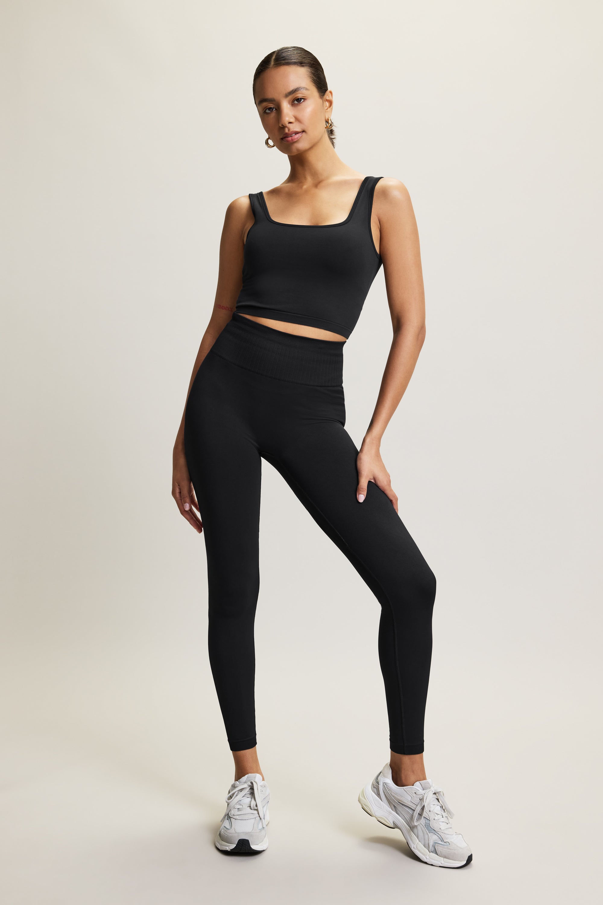 Jilla Active Presence black longline sports bra with a flattering square neckline and removable pads, made from recycled fabric for a supportive and comfortable fit. Styled with matching high-waisted leggings, perfect for low to medium-impact workouts such as yoga, Pilates, or as a versatile everyday athleisure outfit.