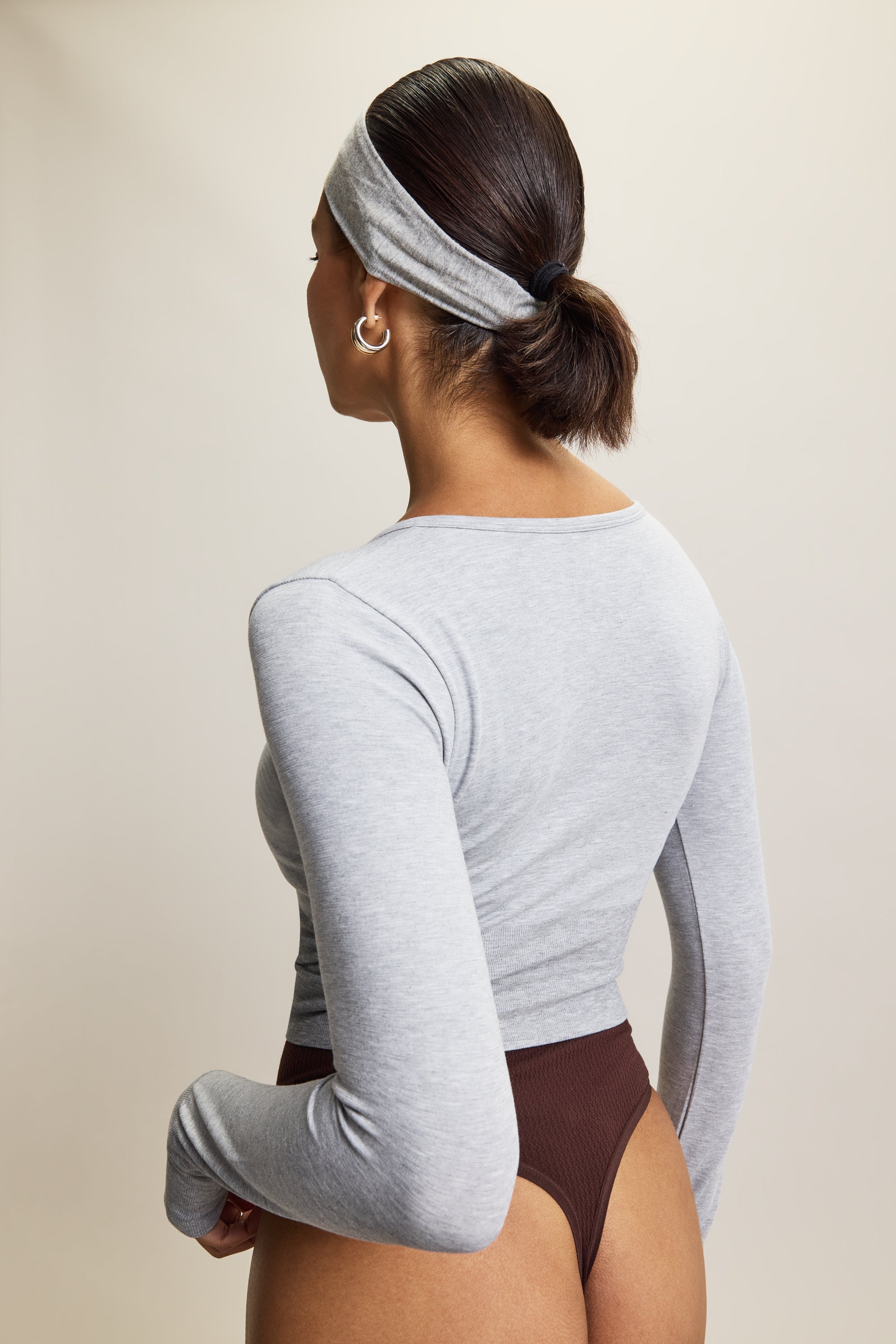 Jilla Active grey stylish cropped long-sleeve athleisure top made from eco-friendly bamboo fabric, featuring a flattering V-neckline, thumbholes for added comfort, and contouring panels for a sculpted fit. Perfect for activewear, this moisture-wicking and breathable top is ideal for workouts, yoga, and casual everyday outfits.